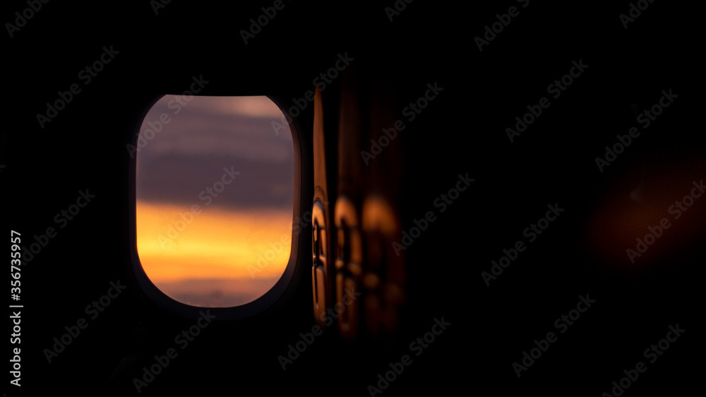 View of the evening sky through the window of the plane. Dark light. A cabin without lighting. Abstract background. View of the evening sky through the window of the plane. Dark light. A cabin without lighting. Abstract background.
