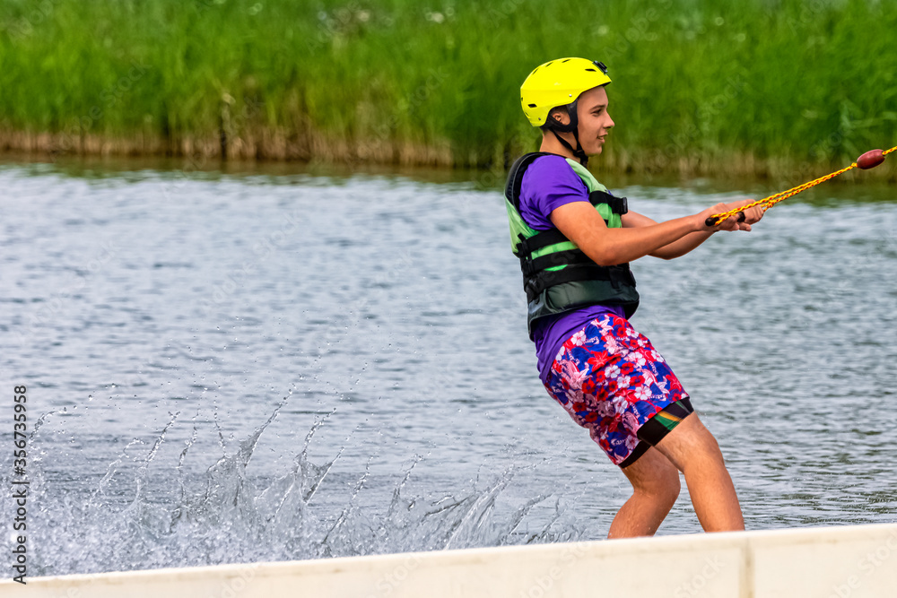 Teenager wakeboarding on a lake - Brwinow, Masovia, Poland Teenager wakeboarding on a lake - Brwinow, Masovia, Poland