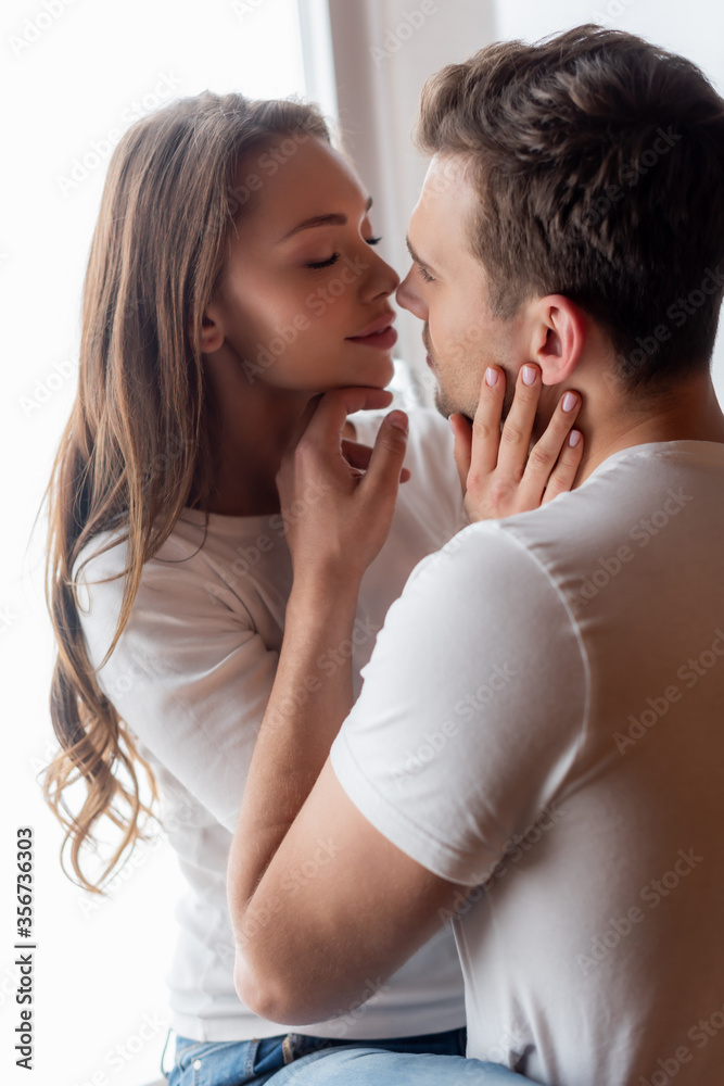 handsome man touching face of beautiful woman at home handsome man touching face of beautiful woman at home