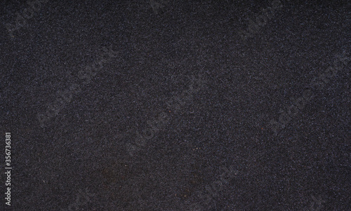 Closeup shot of black foam rubber. Thin sheet of black foam rubber texture