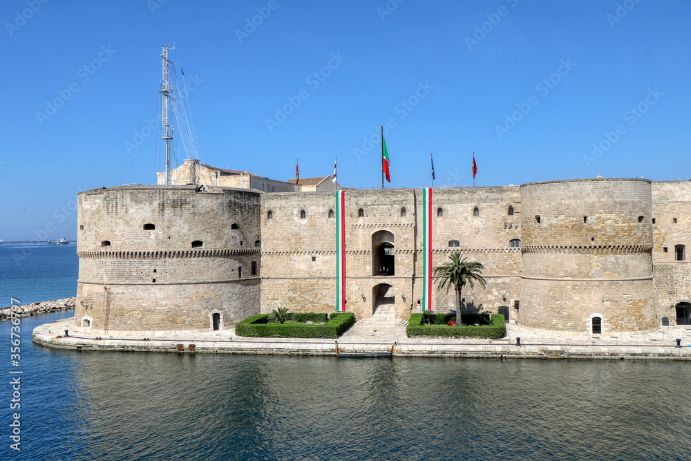 View of the Aragonese Castle with Italian flags to celebrate April 25, Italy's Liberation Day - Taranto, Puglia, Italy