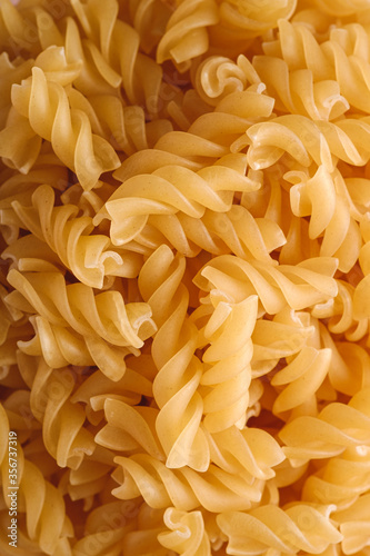Raw wheat golden spiral pasta texture, macro top view