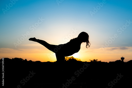 Fototapeta Naklejka Na Ścianę i Meble -  silhouette of woman doing yoga in the sunset