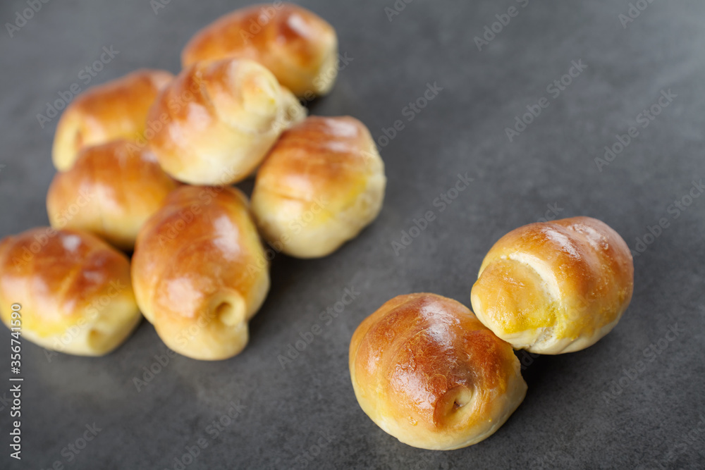 sausage in the dough homemade pastries, rich bagels stuffed with on a dark background sausage in the dough homemade pastries, rich bagels stuffed with on a dark background