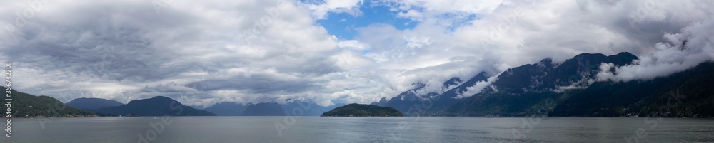 Beautiful Panoramic Canadian Landscape view of Howe Sound during a cloudy and sunny day. Taken near West Vancouver, British Columbia, Canada. Nature Background Panorama
