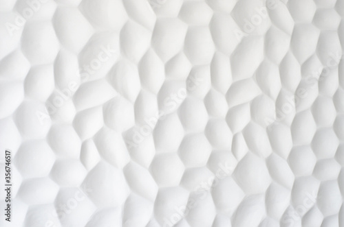 Fototapeta Naklejka Na Ścianę i Meble -  White wall with a wavy texture. Gypsum panels with geometric patterns. Embossed wall in neutral color. Regular repeat cells. Decorative panel made of stone. The texture of the shell.