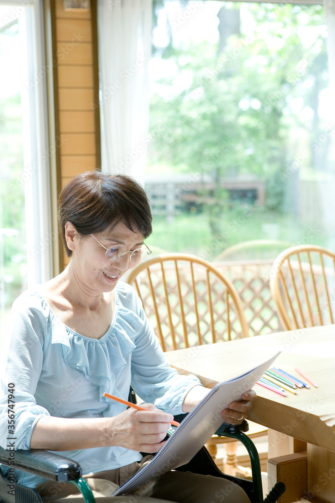 絵を描く車いすの60代女性
