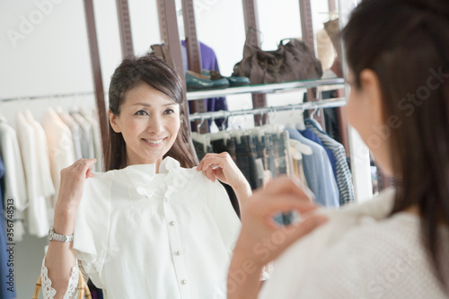 鏡の前で洋服をあてる50代の女性 photo