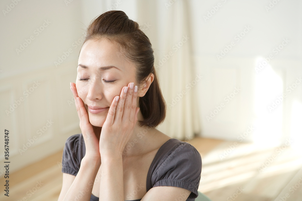 両手を頬にあてる女性 両手を頬にあてる女性