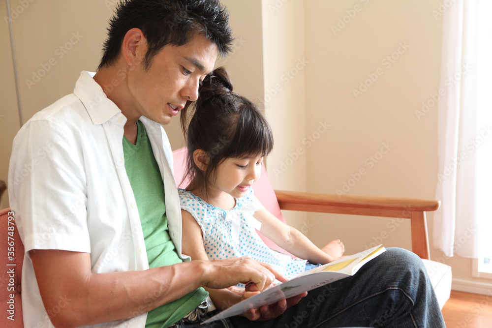 父に絵本を読んでもらう娘 父に絵本を読んでもらう娘