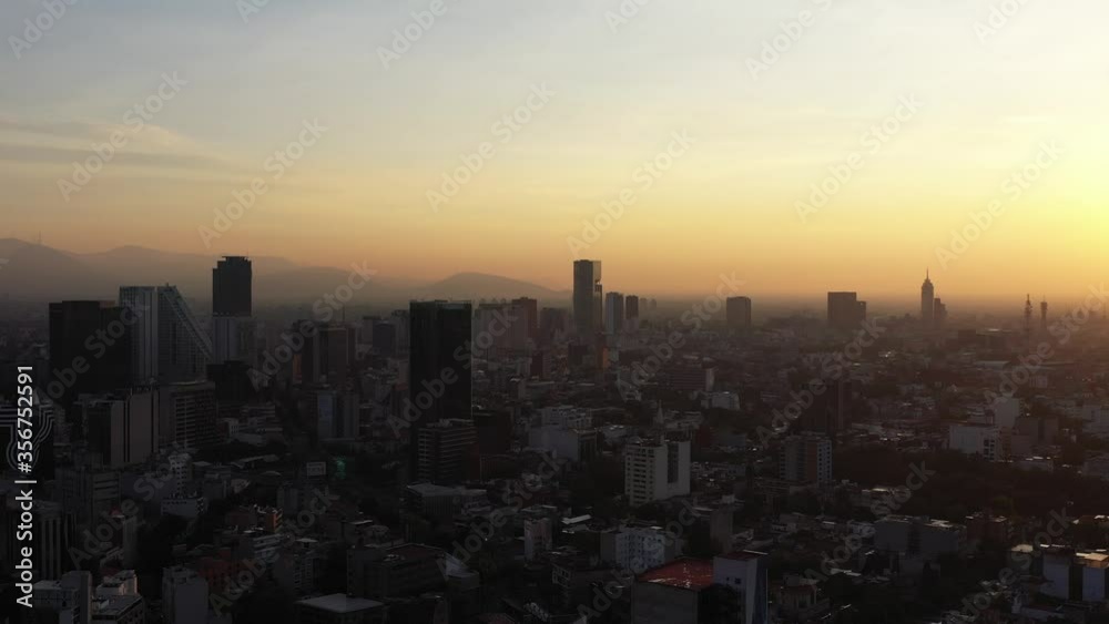Aerial panoramic view of Mexico City skyline during sunrise, drone flying left to right. Aerial panoramic view of Mexico City skyline during sunrise, drone flying left to right.