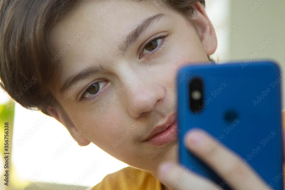 Teenager Holded in Hand Smartphone . Boy look in cell phone and take picture. Teenager Holded in Hand Smartphone . Boy look in cell phone and take picture.