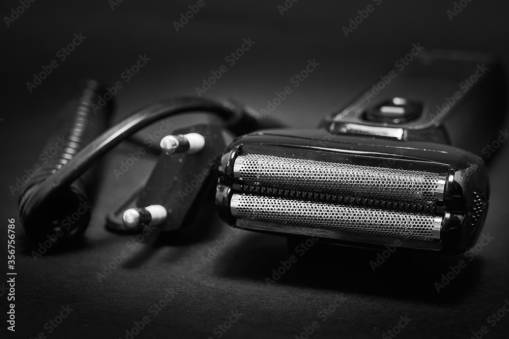 Rechargeable electric shaver for men, black background.