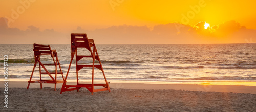 Lifeguard chairs at sunrise