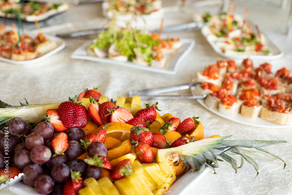 summer time fresh fruit food banquet event strawberry grapes and pineapple pieces on plate