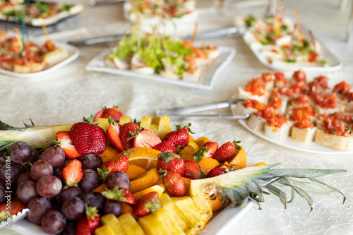 summer time fresh fruit food banquet event strawberry grapes and pineapple pieces on plate