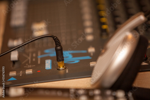 Closeup of an audio mixing control panel, dj equipment, with headphones. Dj Music club life concept