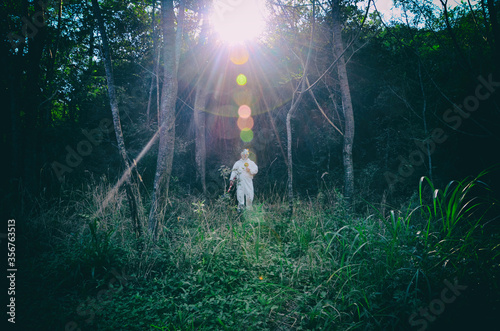 Creepy clown standing in the woods