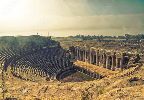 Hierapolis panoramic view to roman amphitheatre ruins with a person standing in the background. Exploration and travel in historical places in Turkey.