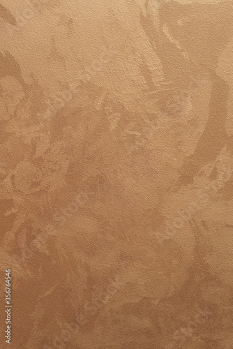 Textured vertical background. Decorative gold plaster imitating a vintage wall. Background image of a textured wall.