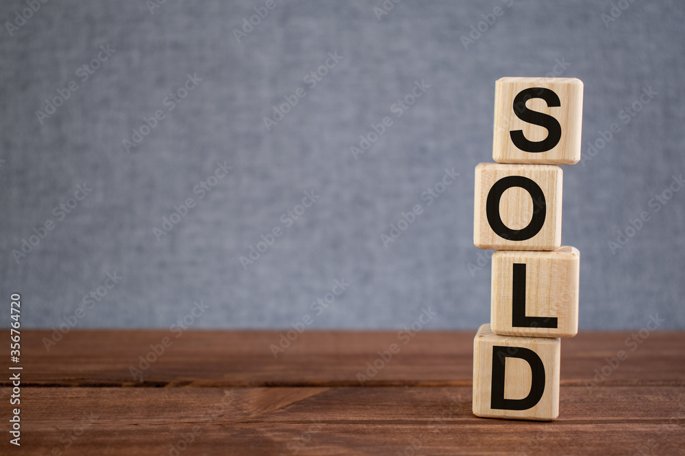 Word SOLD text on wooden cubes on dark wooden backround. Concept image. Word SOLD text on wooden cubes on dark wooden backround. Concept image.