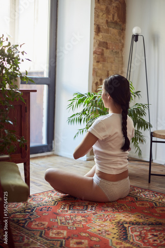 Young Asian woman practicing meditative exercises indoors
