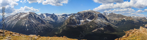 Panorama from Forest Canyon overlook in Rocky Mountain National Park, Colorado, USA, with unrecognizable people admiring mountain tops and cirque formed by glacial erosion long ago