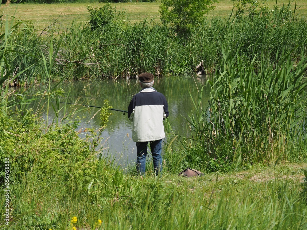 Budapest, hungary - june 03, 2020: Old man fishing at a lake in Budapest suburb Budapest, hungary - june 03, 2020: Old man fishing at a lake in Budapest suburb