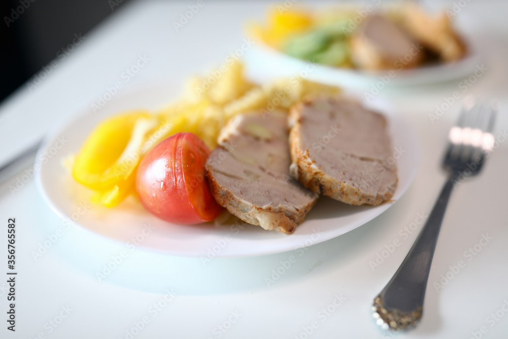 Close-up of yummy bright breakfast. Cucumber tomato slices of meat and fresh yellow pepper. Delicious portion for couple served on white plate with fork. Healthy eating and food concept Close-up of yummy bright breakfast. Cucumber tomato slices of meat and fresh yellow pepper. Delicious portion for couple served on white plate with fork. Healthy eating and food concept