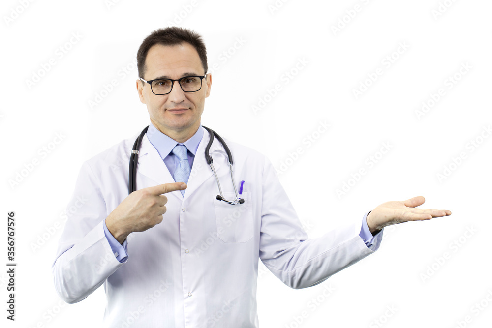 Friendly beautiful male doctor in medical uniform points with finger to empty open palm holding advertised product isolated on white background. Health, healthcare, insurance and clinic ads concept Friendly beautiful male doctor in medical uniform points with finger to empty open palm holding advertised product isolated on white background. Health, healthcare, insurance and clinic ads concept