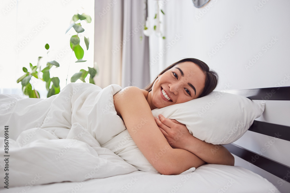 Happy young female embracing pillow at morning Happy young female embracing pillow at morning