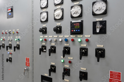 An electrical generation panel with buttons, gauges and switches