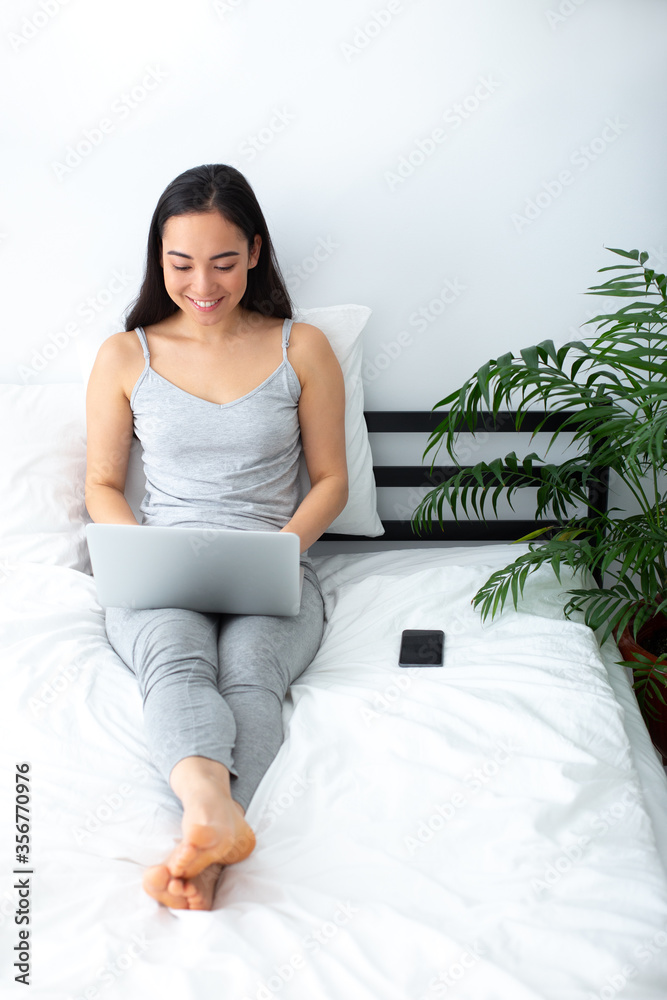 Cheerful young woman spending morning with gadgets Cheerful young woman spending morning with gadgets