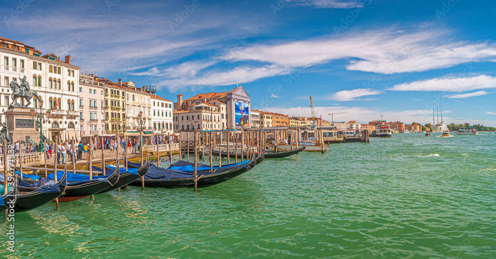 Panoramic view over busy Grand Canal, piers, promenade embankment, colorful buildings and Monument of King Victor Emmanuel II in Venice, Italy