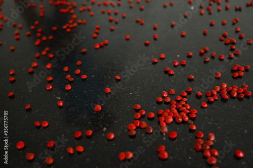 Red sandalwood (Adenanthera pavonina) seeds isolated on a black background. Manchadi, Manjadi, Manjetti, Peacock flower fence, Acacia Coral, Anikundumani, Bandi guruvenda, Barbados pride, Barricarri. photo