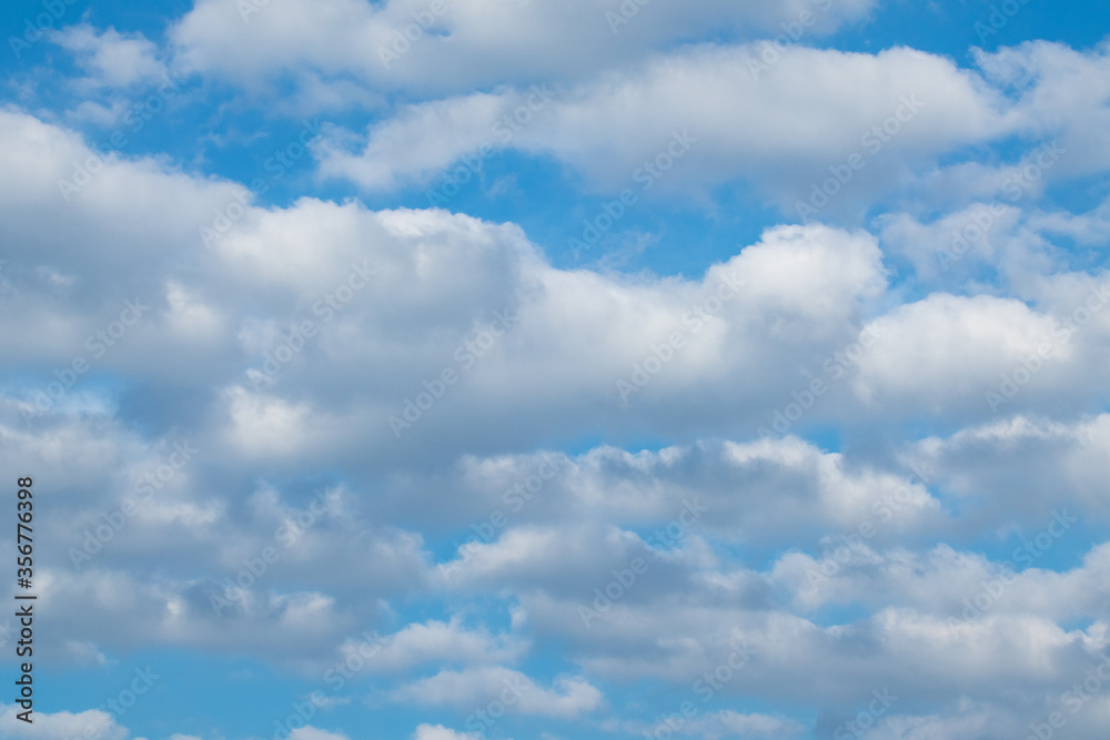 Fluffy white clouds on bright blue sunny sky background. Skyscape natural harmony Fluffy white clouds on bright blue sunny sky background. Skyscape natural harmony