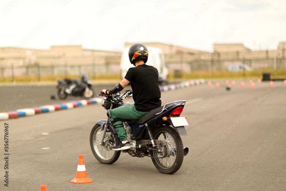 Driving school driving lessons. Motorcyclist on a motorcycle. young man learning how to drive motorbike. Driving instructor advising man driving a motorbike. Close up of a motorbiker hand starting.