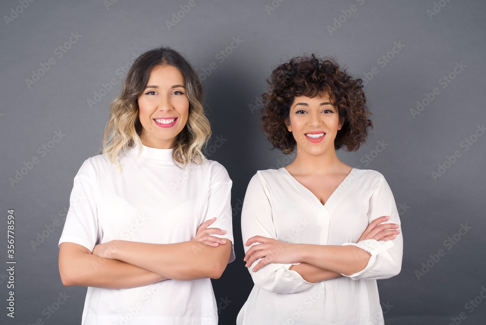 Brunette girl happy face smiling with crossed arms looking confident at the camera standing against gray wall. Positive person. Brunette girl happy face smiling with crossed arms looking confident at the camera standing against gray wall. Positive person.