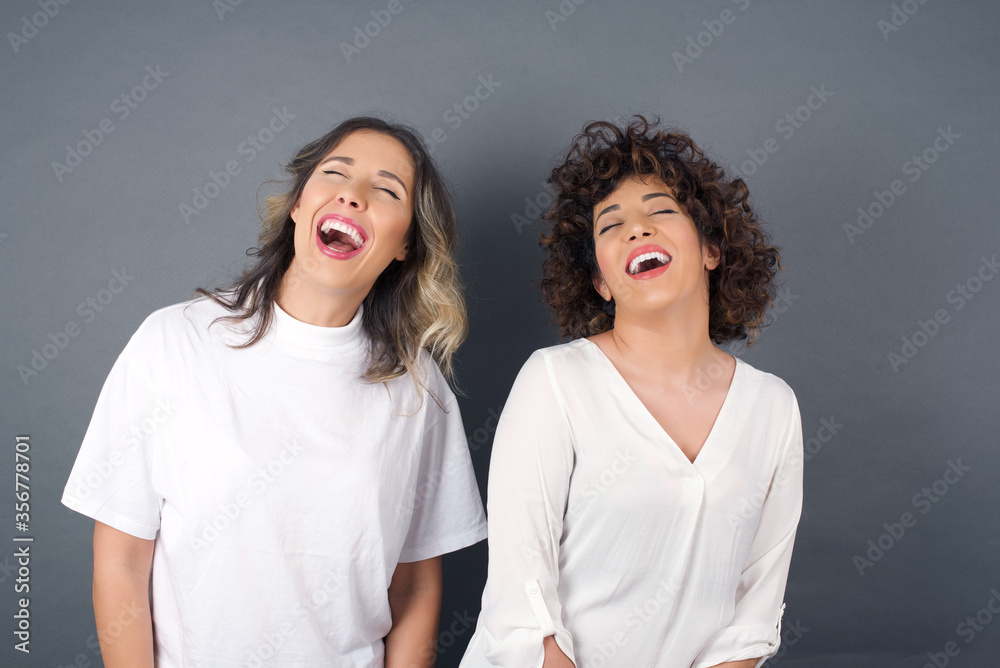 Horizontal portrait of pleasant-looking Caucasian female with long beautiful hair wearing brown sweater covering her face with hair looking happily to the camera.