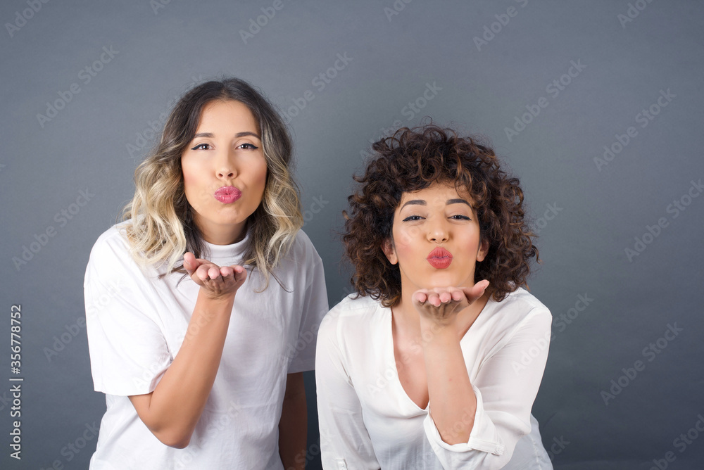 Cute appealing female blows kiss at camera, demonstrates love to boyfriend or says goodbye on distance, isolated over white studio background. Attractive young woman shows sympathy to someone. Cute appealing female blows kiss at camera, demonstrates love to boyfriend or says goodbye on distance, isolated over white studio background. Attractive young woman shows sympathy to someone.