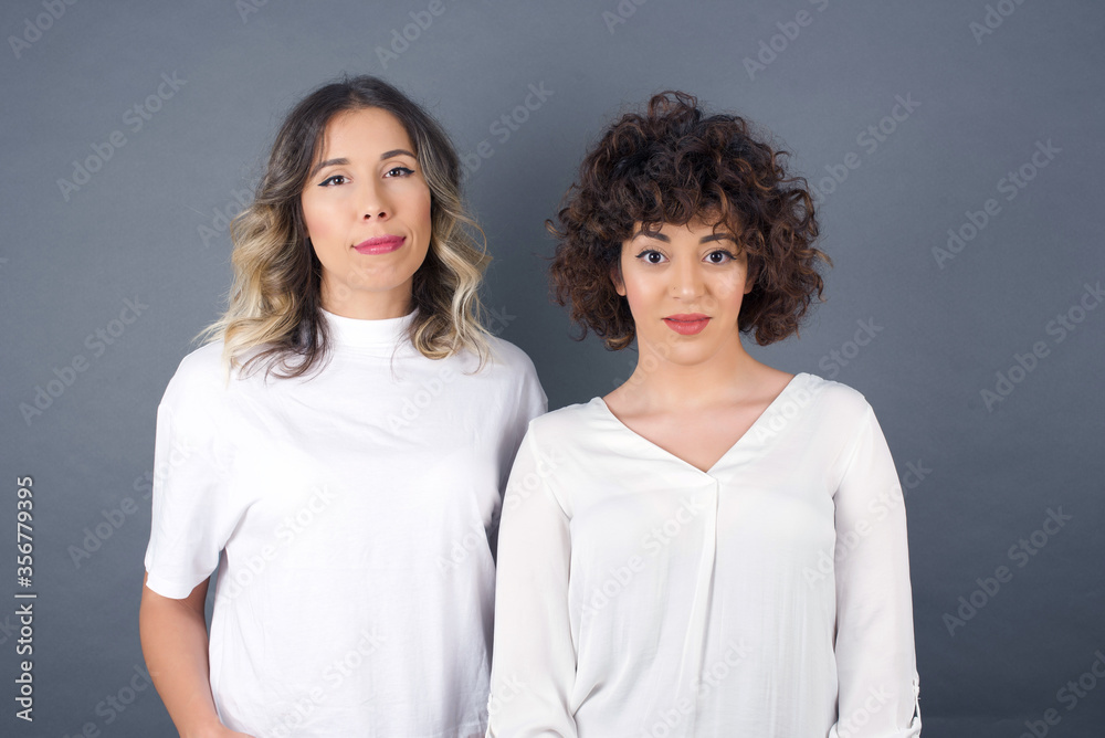 Young beautiful woman over isolated background happy face smiling with hands in pockets looking at the camera. Positive person. Young beautiful woman over isolated background happy face smiling with hands in pockets looking at the camera. Positive person.