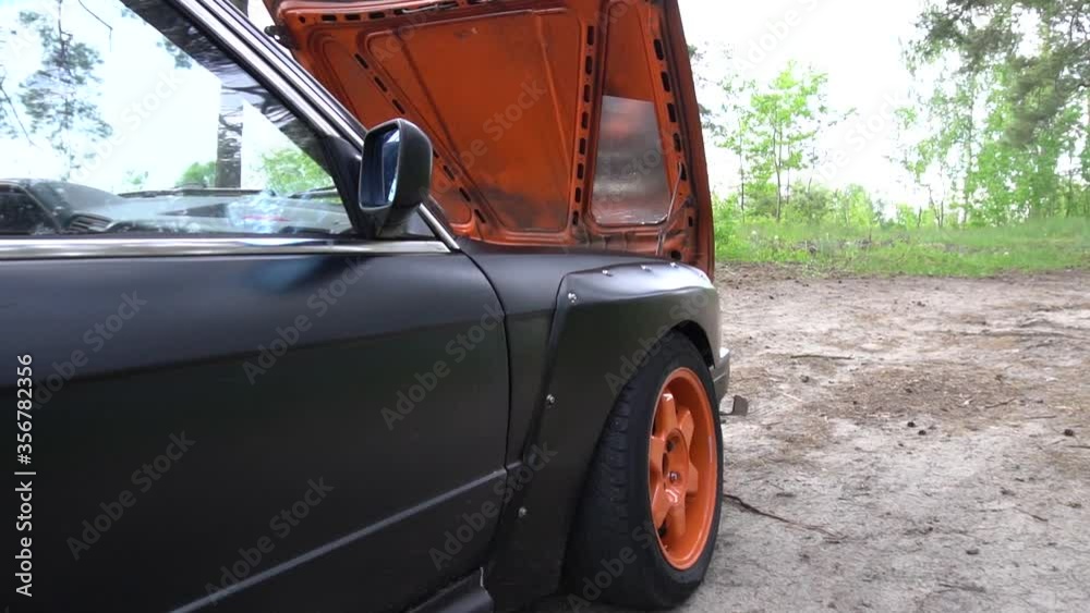 my black car with orange wheels in a green forest in summer my black car with orange wheels in a green forest in summer