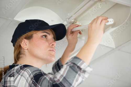 woman replacing light bulb at home