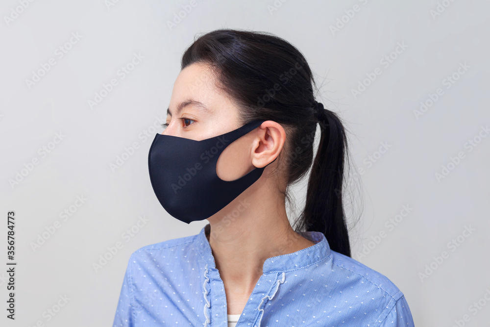Girl in a protective medical mask. Prevention of viral diseases of the common cold and flu. Light gray background. In a respiratory mask. Girl in a protective medical mask. Prevention of viral diseases of the common cold and flu. Light gray background. In a respiratory mask.
