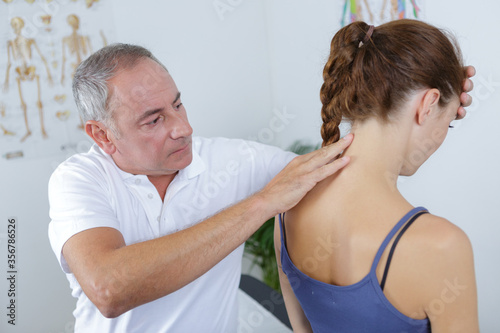 Принти на полотні male physiotherapist working on young female patients back