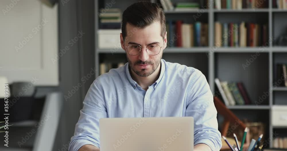 Overjoyed young businessman reading email on computer, surprised by unexpectedly good news, online lottery win notification, excited by successful investment round raising, bank loan credit approval.
