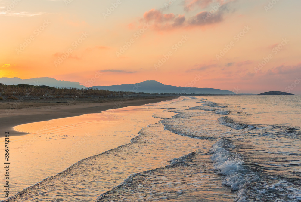 Fantastic Mediterranean seascape in Turkey. Amazing sunrise on Patara beach, Mugla Province. 
Morning orange clouds reflected in calm water.