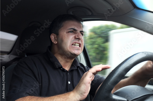 Angry man driver honking while driving car without seat belts