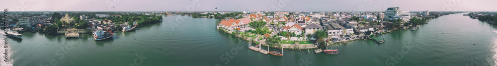 MAEKLONG, THAILAND - DECEMBER 15, 2019: Panoramic aerial view of famous railway market and city skyline from the river