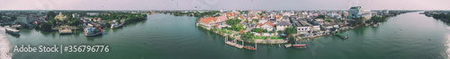 MAEKLONG, THAILAND - DECEMBER 15, 2019: Panoramic aerial view of famous railway market and city skyline from the river